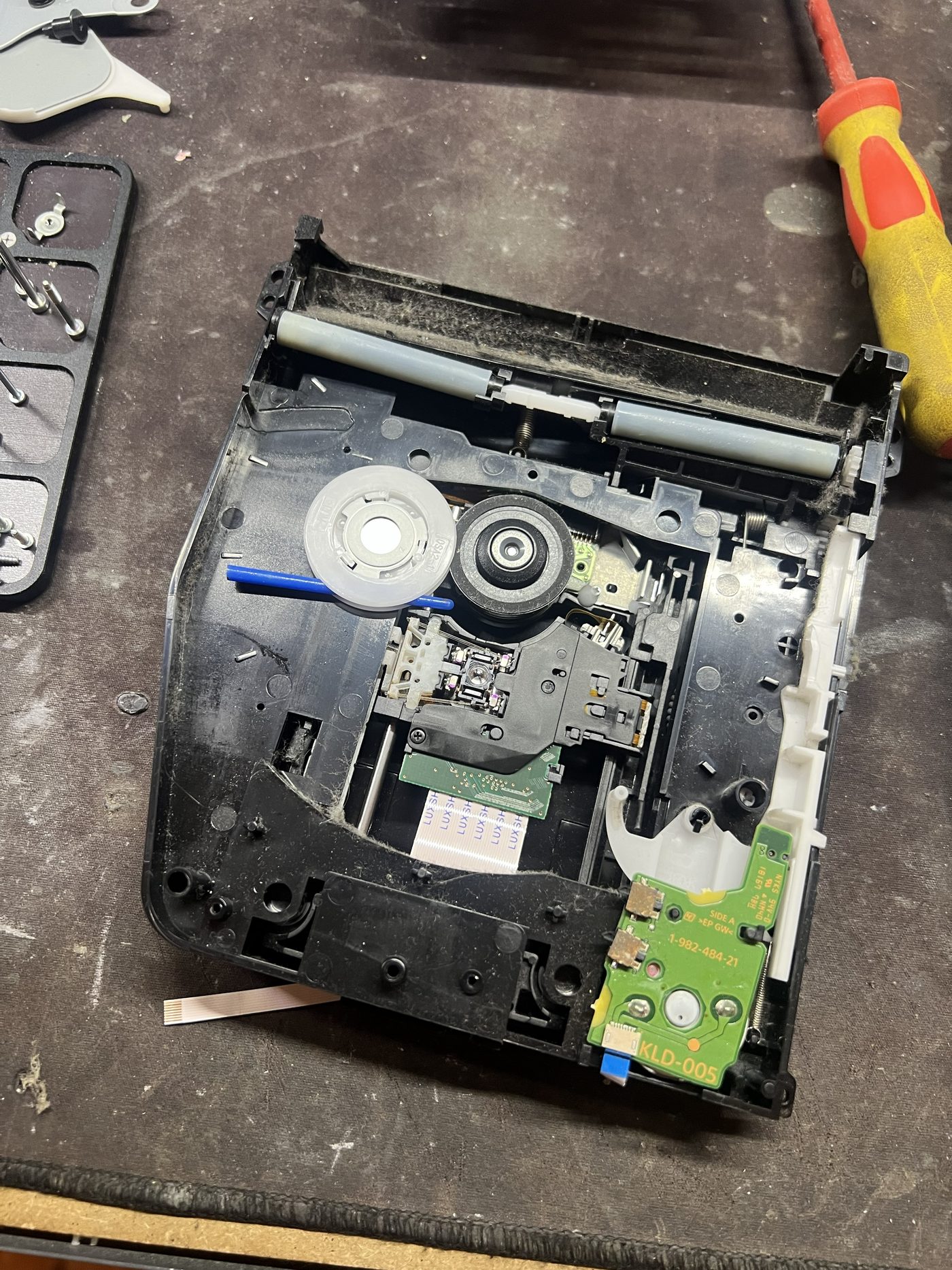 PS4 Slim Blu-ray drive opened with a foreign object visible inside